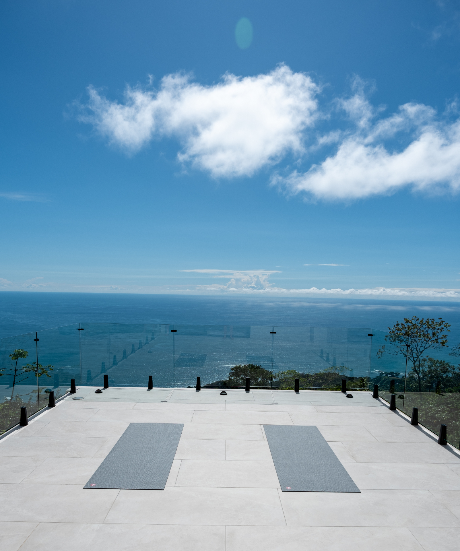 Oceanfront yoga deck with mats overlooking the Pacific at Casa Cascada
